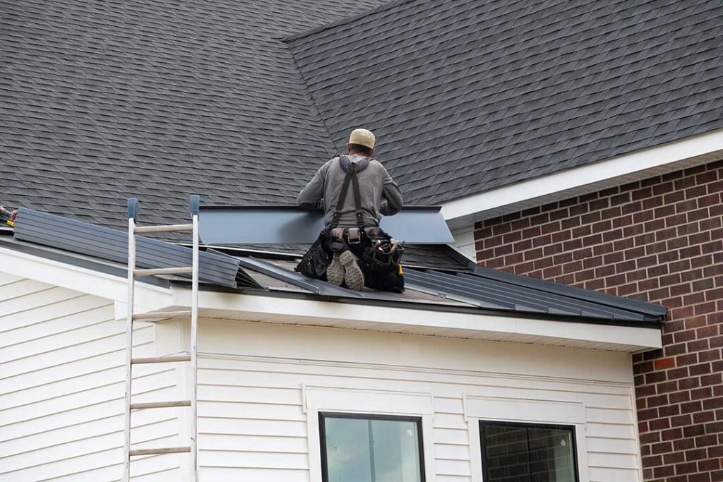 Homeowner using binoculars to inspect a shingle roof for storm damage from the ground after rainfall.